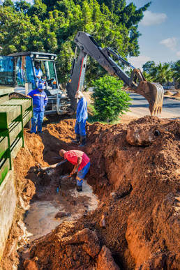 Technicians excavating underground plumbing to reach a leaking water line